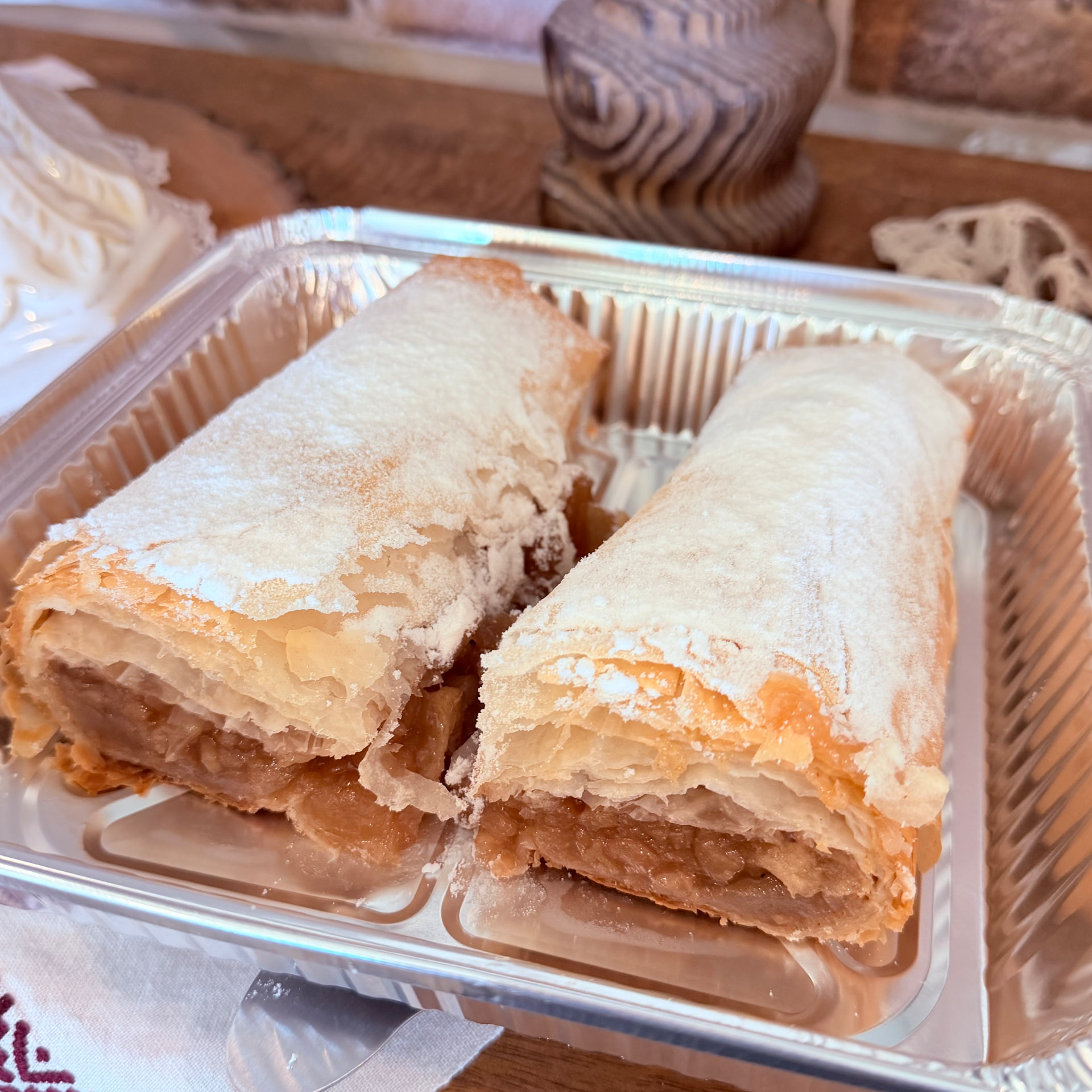 Freshly baked apple strudel dusted with powdered sugar in an aluminum baking pan — Strudel from Mama Rozi's Bakehouse in LaGrange, KY