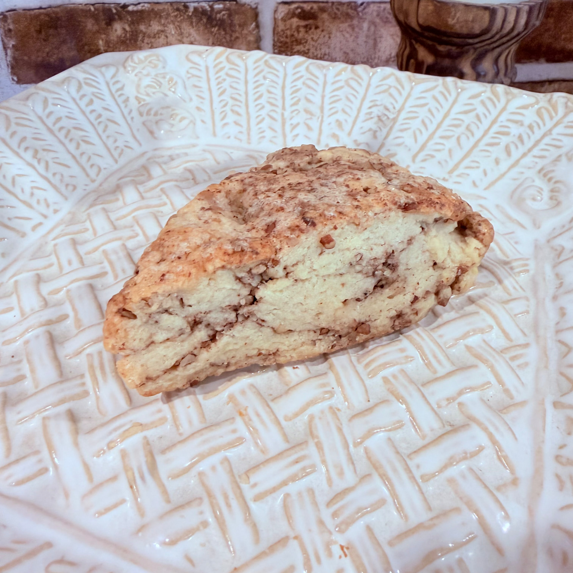 Maple pecan scone filled with toasted nuts on a patterned plate — baked fresh at Mama Rozi's Bakehouse in LaGrange, KY