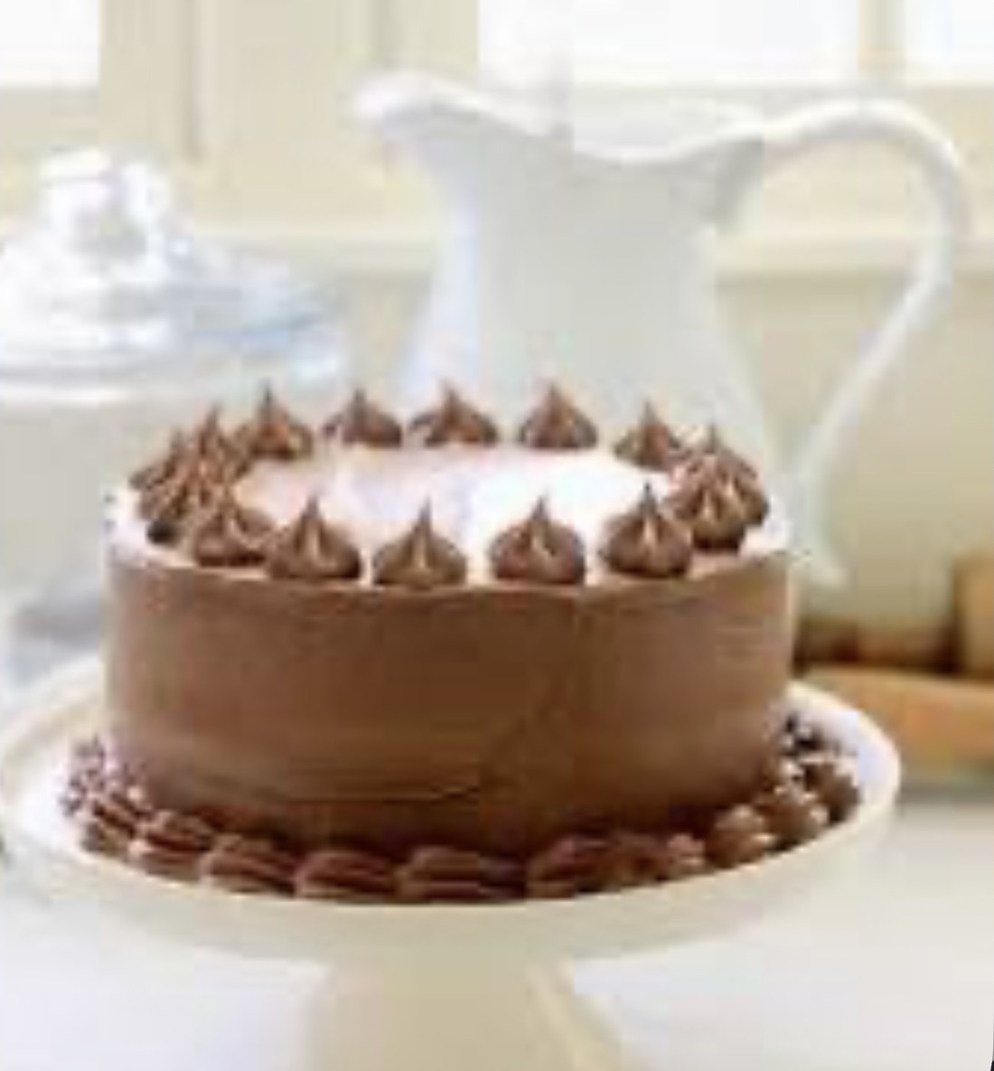 Chocolate mousse celebration cake with chocolate buttercream dollops on a white cake stand — Mama Rozi's Bakehouse in LaGrange, KY