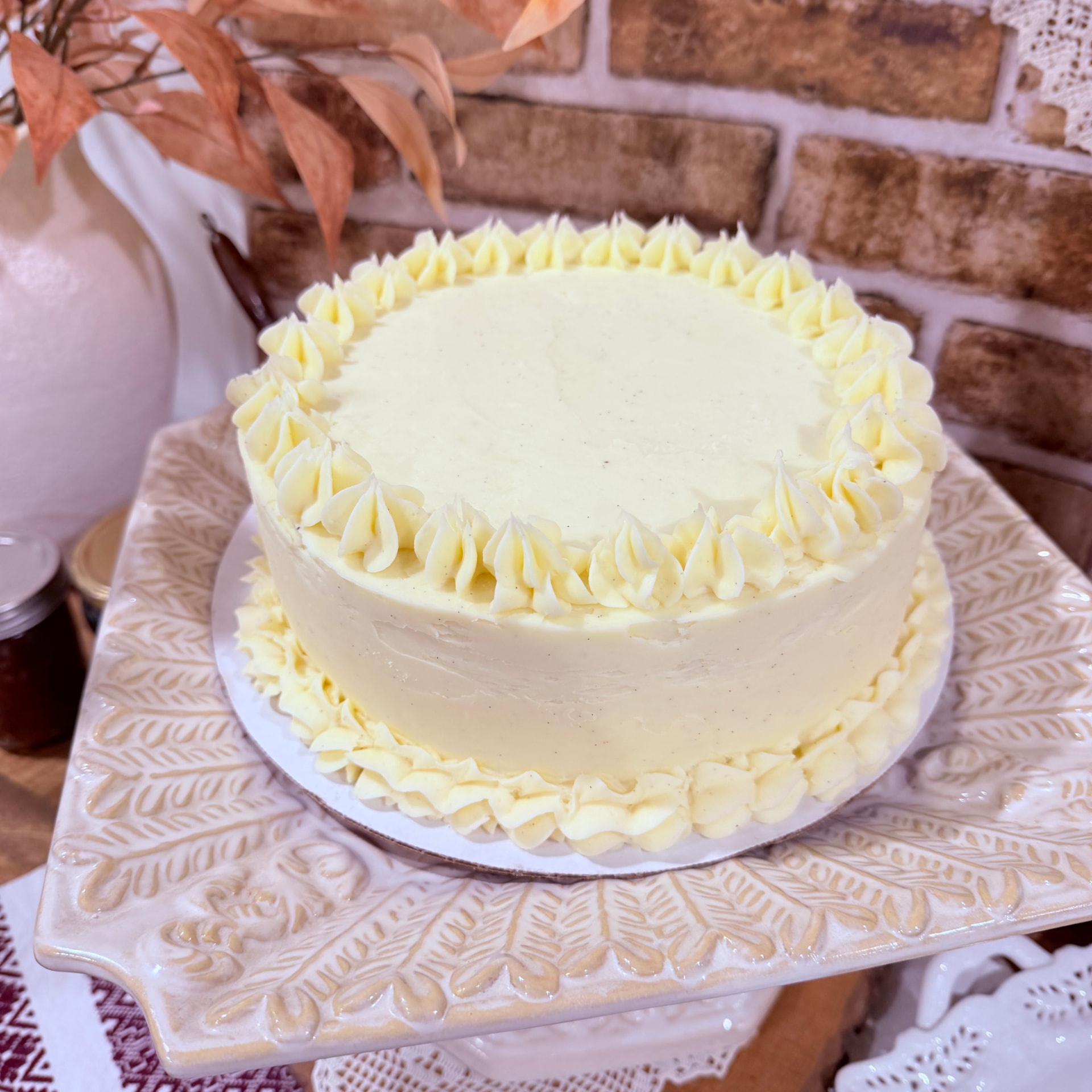 Honey vanilla celebration cake with piped vanilla buttercream shell borders on a white plate — Mama Rozi's Bakehouse in LaGrange, KY