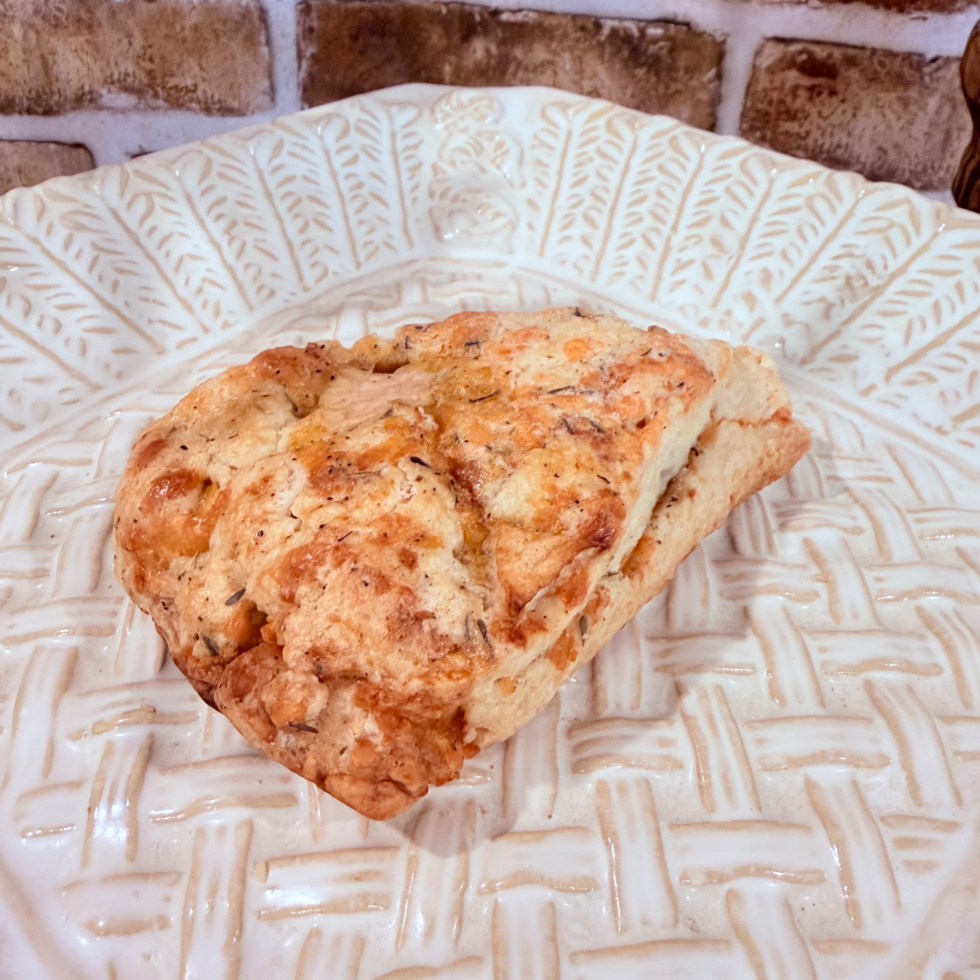 Savory apple cheddar thyme scone on a patterned plate — baked fresh at Mama Rozi's Bakehouse in LaGrange, KY