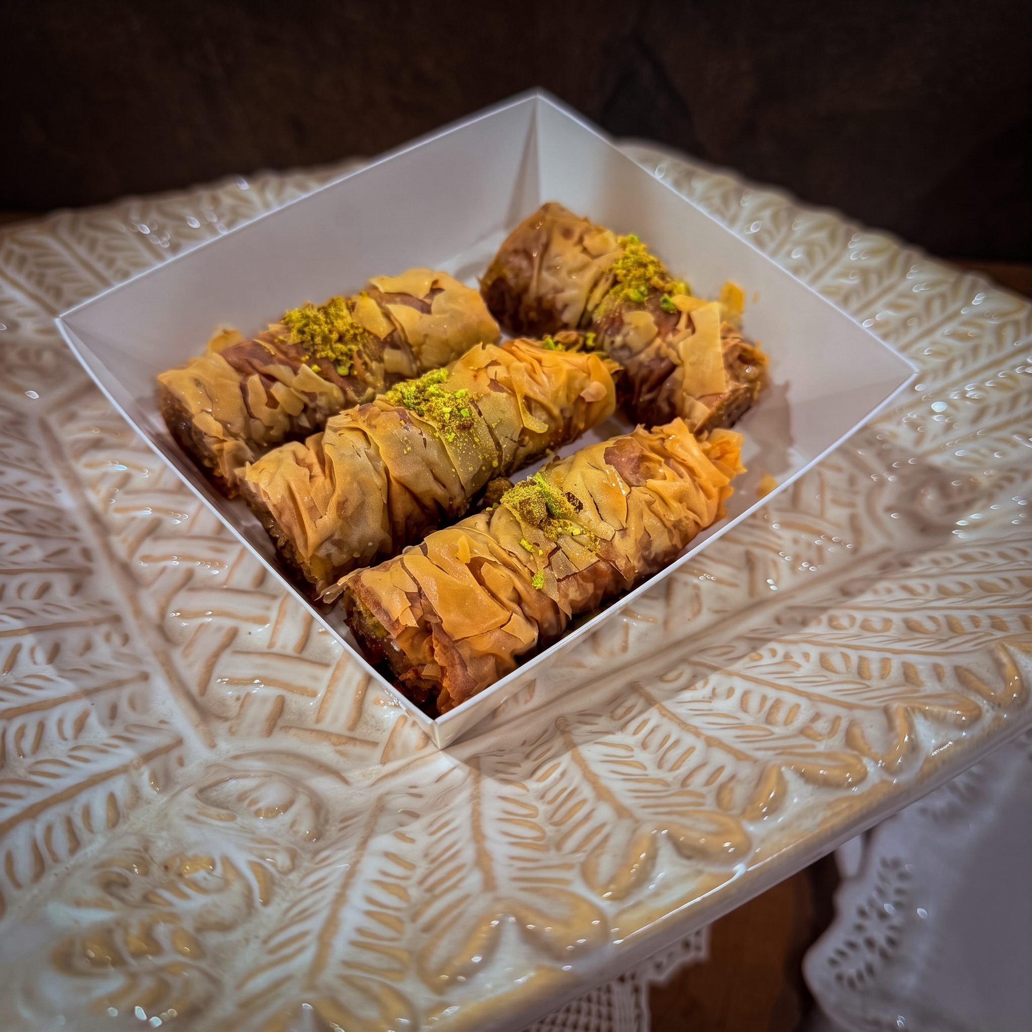 Pistachio Baklava — Crisp phyllo layered with ground pistachios and honey syrup, topped with crushed pistachios. Four 2×2 inch pieces per box. Available to order for pickup from Mama Rozi's Bakehouse, LaGrange, KY.