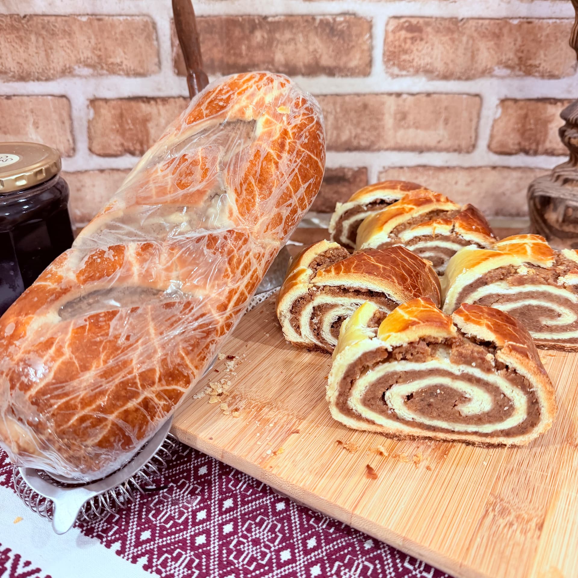 Hungarian roll with walnut swirl filling — one wrapped loaf and sliced rolls on a wooden board — Hungarian Roll from Mama Rozi's Bakehouse in LaGrange, KY